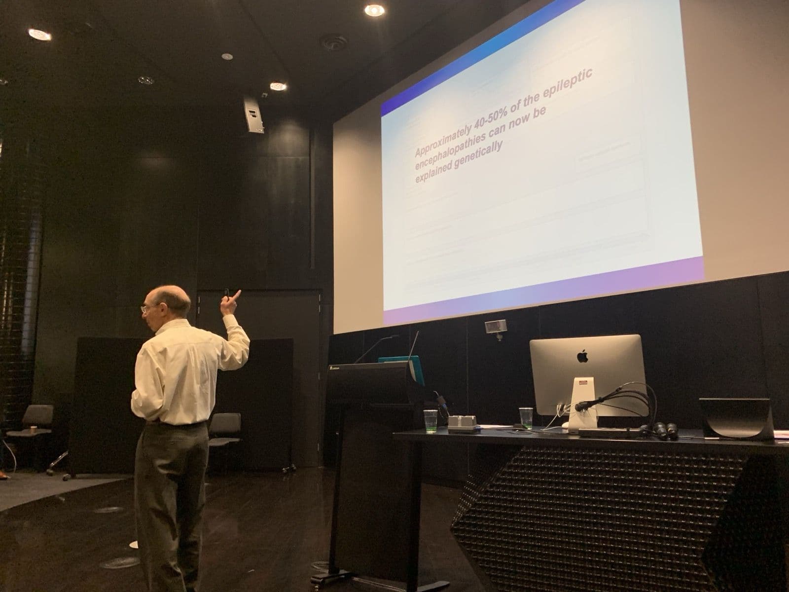Prof Daniel Lowenstein presenting in front of a projected slide